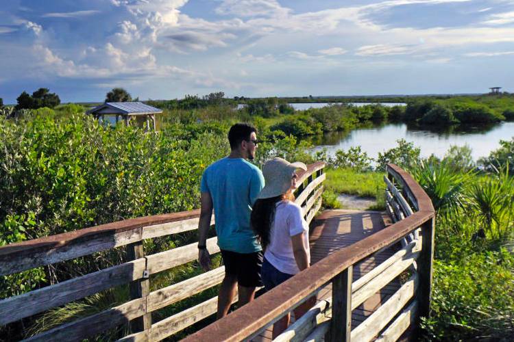 Couple of East Coast Living vacation renters enjoying a hike at Cape Canaveral Wildlife Preserve
